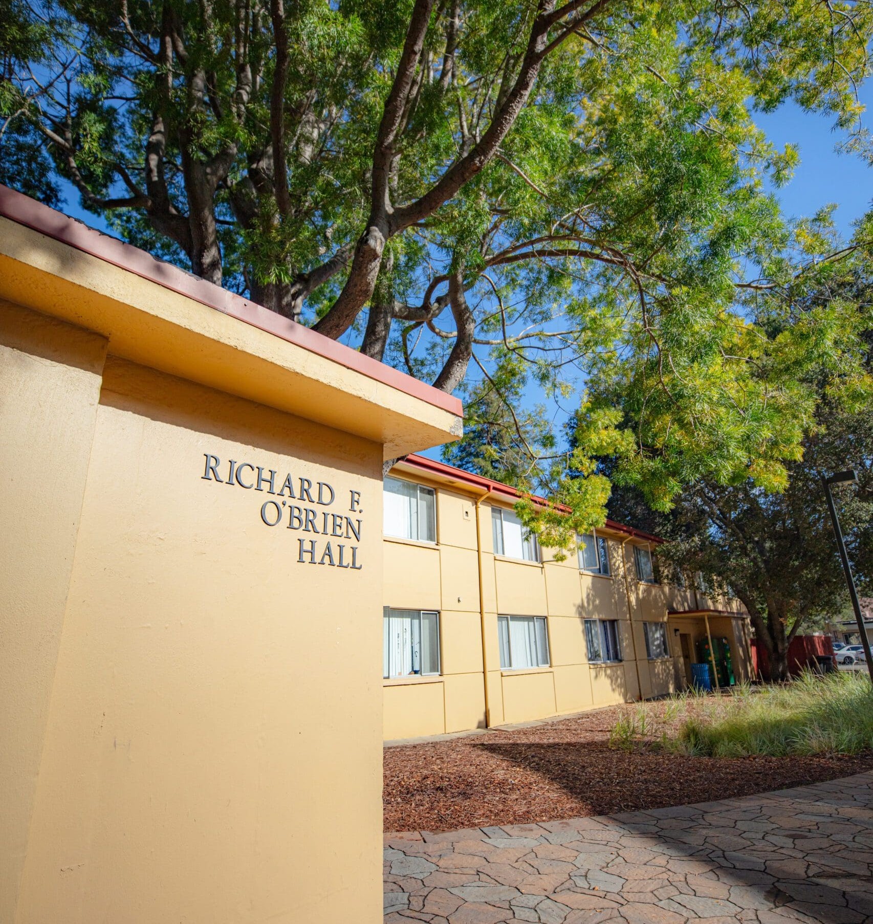 An exterior picture taken from the corner angle looking at the sign for O'Brien Hall at Menlo College 