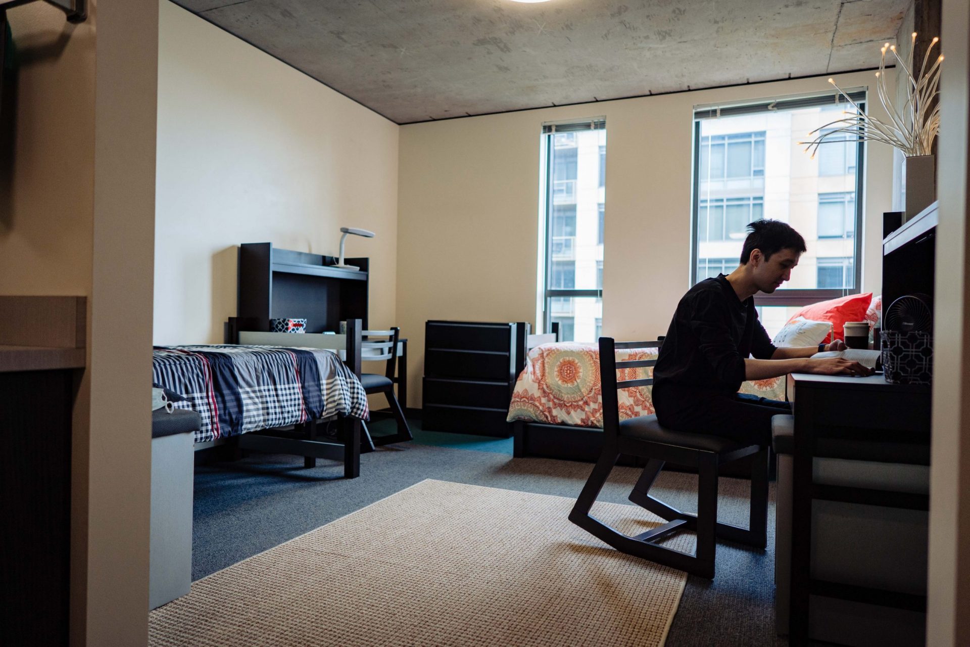 Cornish Commons dorm room with student sitting at desk working