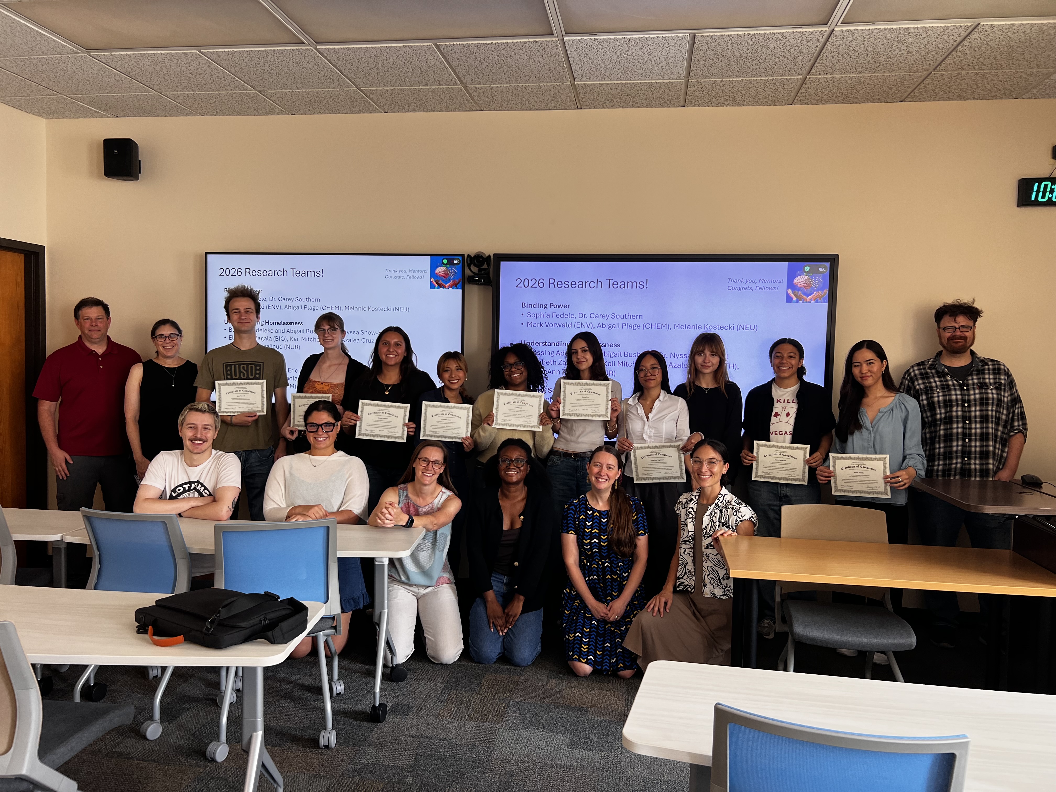 Group of interns in a classroom holding certificates