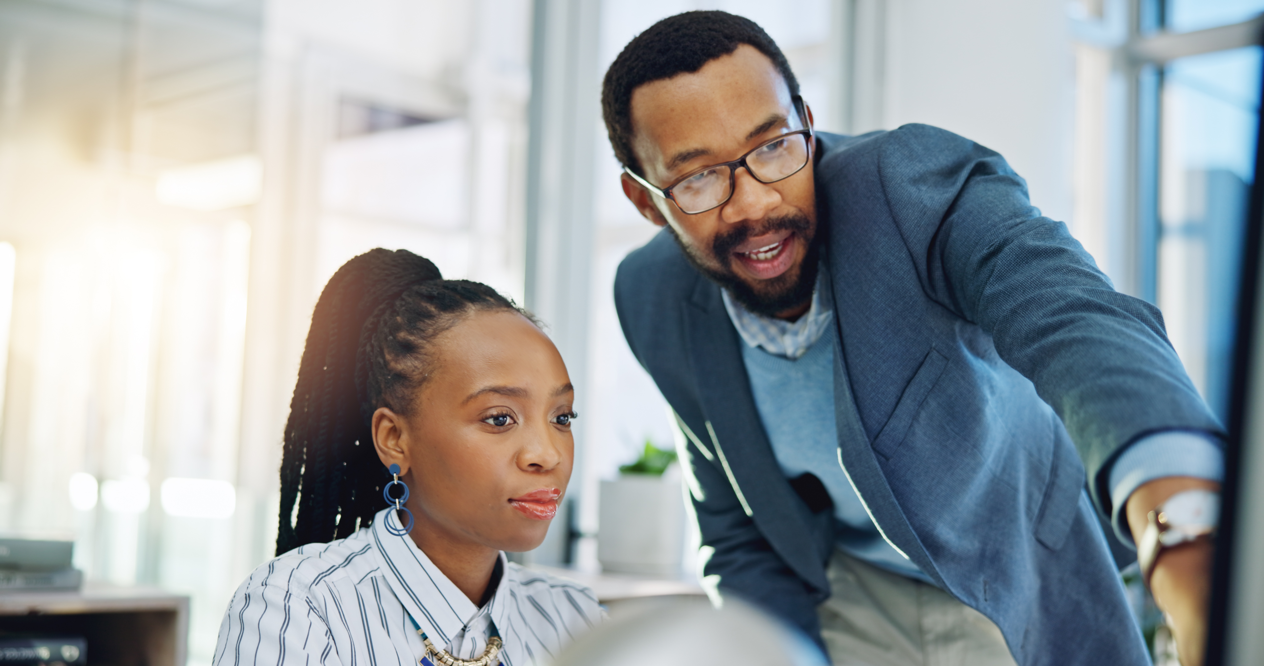 Career advisor helping college student at a computer
