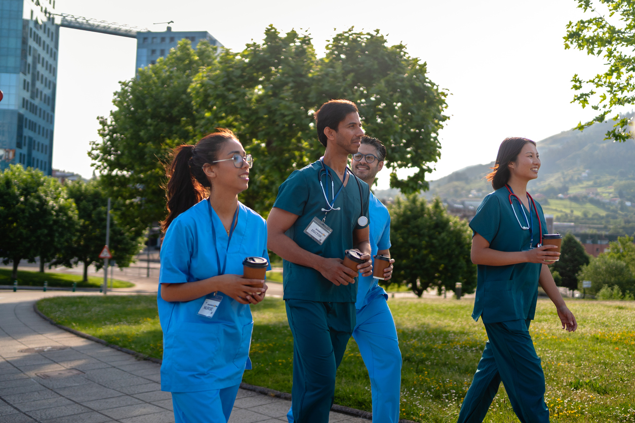 Medical interns walking on a hospital campus outside