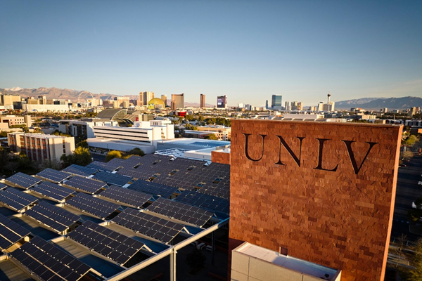 A skyline view of the UNLV on the side of a brick building with the Vegas skyline in the back