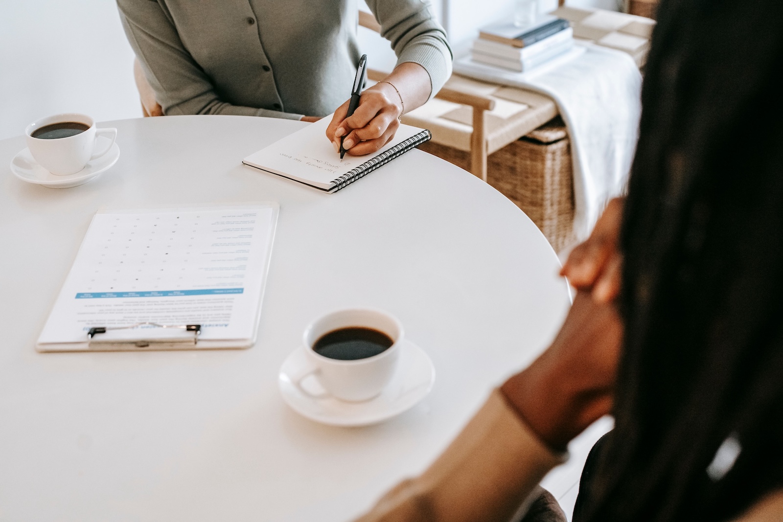 Two people sitting at a table with coffee and paperwork