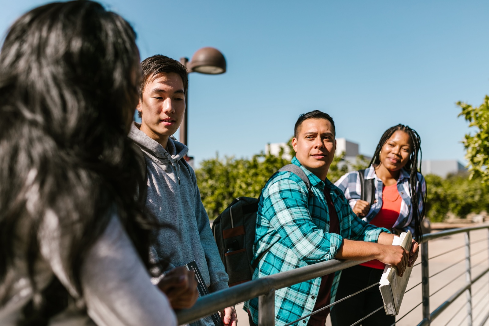 Group of four students standing outside on campus