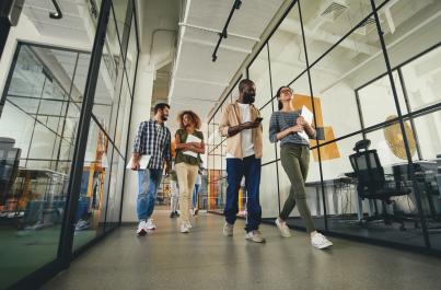 Four interns walking through the hallway of a business office