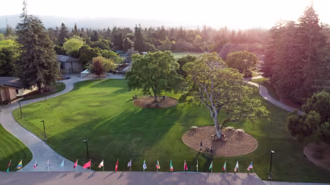 Ariel shot of of the Menlo College green space and a line of flags along the bottom of the picture