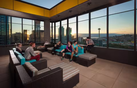 A picture of the open-air atrium with view of seattle skyline at sunset  