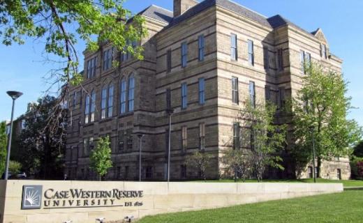 A picture of the Case Western Reserve University sign with a large building in the background