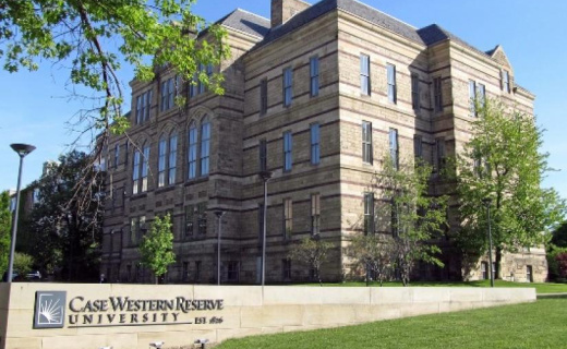 A picture of the Case Western Reserve University sign with a large building in the background