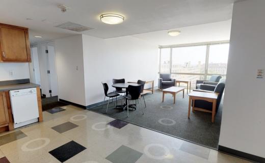 Wide angle shot of kitchen, living room, and hallway.