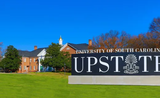 The USC Upstate sign at an angle with green landscaping