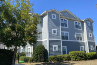 An outside view of a Freedom's Landing building with three floors of apartments included porches
