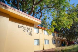 An exterior picture taken from the corner angle looking at the sign for O'Brien Hall at Menlo College 